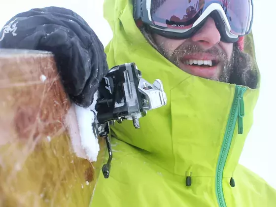 Skier holding skis looking down the barrel Dax Justin