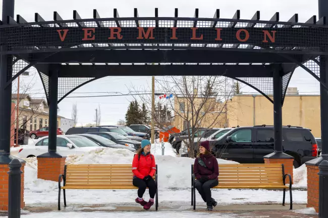 Two people sitting on a bench in downtown Vermillion